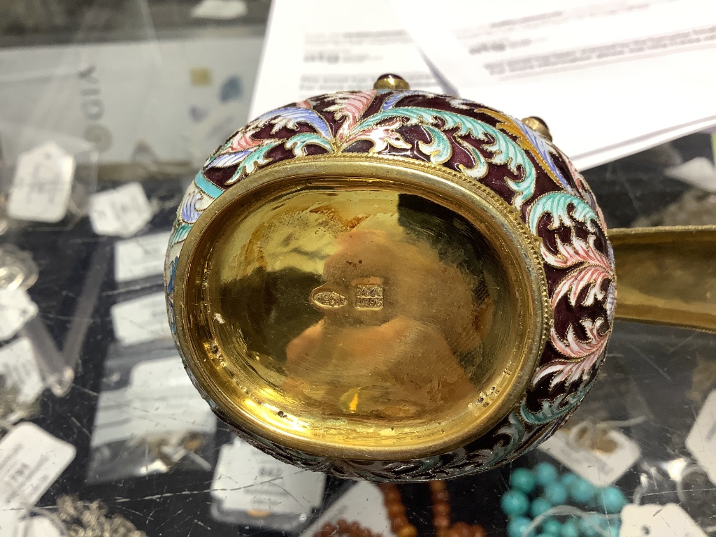 A group of Russian style white metal and enamel items including kovshs, egg pendants and small cups.